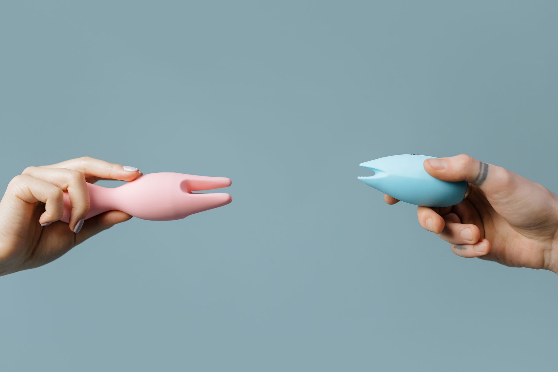 A person holds colorful clitoral vibrators, representing tools for reclaiming body autonomy after trauma.